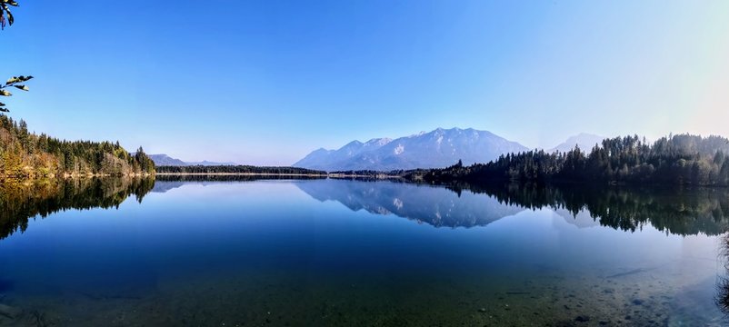 Scenic View Of Lake And Mountains Against Clear Blue Sky