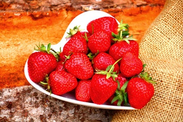 Frisch gepflückte Erdbeeren  schale auf hölzernem Hintergrund