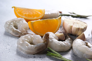 Seafood. Raw green royal  prawns shrimp  with rosemary, lemon, garlic and salt on a light grey background. Background image, copy space
