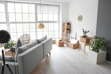 Cardboard boxes with belongings in new flat on moving day