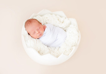 Neweborn sleeping in egg shaped cradle