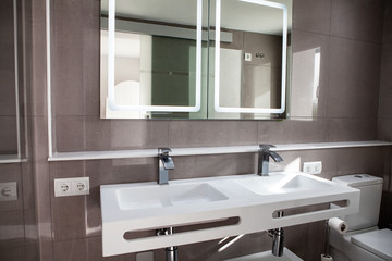 Spacious bathroom in gray tones with heated floors, walk-in shower, double sink vanity and skylights