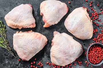 Fresh chicken thigh, organic poultry meat. Black background. Top view