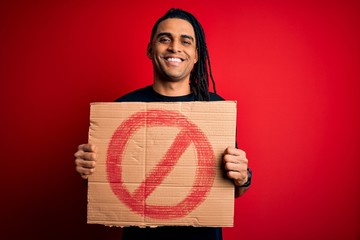 Young handsome african american man with dreadlocks holding banner with prohibited signal with a happy face standing and smiling with a confident smile showing teeth
