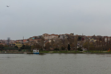 Naklejka premium View of a residential area of Istanbul from the Golden Horn Bay in rainy weather. Turkey