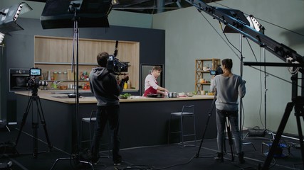 WIDE Behind the scenes of studio set, shooting TV television cooking show featuring celebrity chef, professional TV production