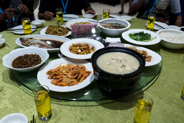 Various chinese meals on a table in a chinese restaurant