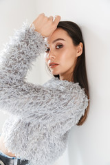 Image of stylish asian woman looking at camera while leaning on wall