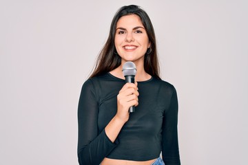 Young beautiful singer performer girl singing using music microphone over isolated background with a happy face standing and smiling with a confident smile showing teeth