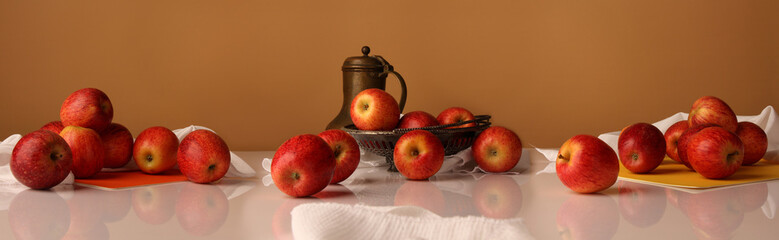 Large-format panorama with an old jug and apples on a glossy table