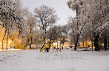 Fototapeta na wymiar Lonely playground during the evening snowfall.