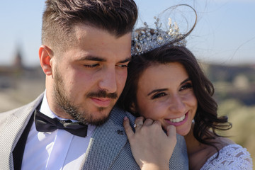 Close-up portrait of the bride and groom. The bride hugs the groom from behind.