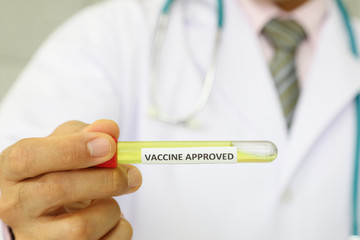 Doctor holding newly discover approved vaccine from laboratory in tube with copy space