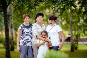 Mature Female Friends Socializing In Backyard Together.