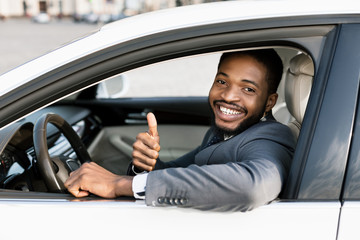 Businessman Gesturing Thumbs-Up Sitting In Driver's Seat After Test Drive