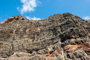 Cliff of colored rocks. Los Gigantes rocks - a close-up view from below.