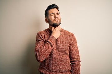 Young handsome man wearing casual sweater standing over isolated white background Touching painful neck, sore throat for flu, clod and infection