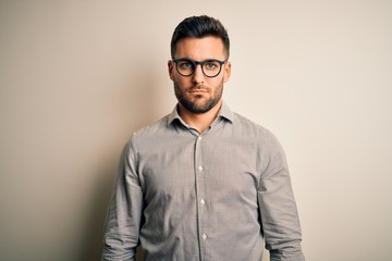 Young handsome man wearing elegant shirt and glasses over isolated white background depressed and worry for distress, crying angry and afraid. Sad expression.