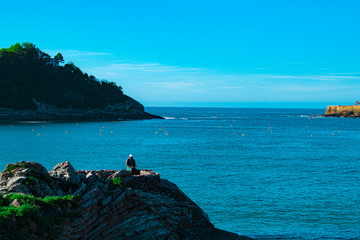 Persona sentada en las rocas