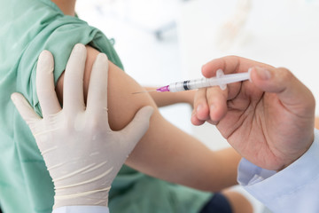 Close up of a Doctor making a vaccination in the shoulder of patient, Flu Vaccination Injection on Arm, coronavirus, covid-19 vaccine disease preparing for human clinical trials vaccination shot..