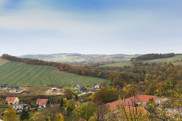 Fototapeta na wymiar Polska , Dolny Śląsk, krajobraz widoczny z murów zamku Bolków, domy i pola, drzewa w jesiennych kolorach