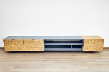 Floating media cabinet in contemporary living room. Wall mounted wooden cabinet