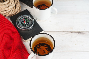 Compass surrounded by mountain gear tools on wooden background