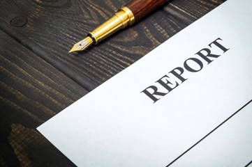 Report form with stylish pen on a working vintage black table