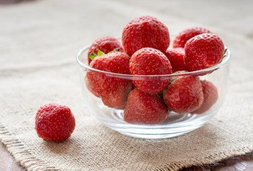 Fresh juicy ripe strawberries in a small Cup on a wooden table.