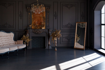 Black room interior with a vintage sofa, chandelier, mirror and fireplace