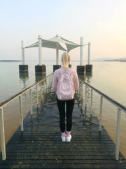Fototapeta premium Girl tourist looks at the Dead sea. Back view with backpack. Israel.