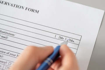 Woman filling hotel reservation form putting check mark on Mrs. Reception desk. Hotel service,...