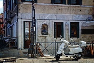 Fototapeta na wymiar typical Italian street scene with a scooter parked in front of a restaurant