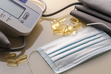 blood pressure monitor with medical disposable mask on a light table