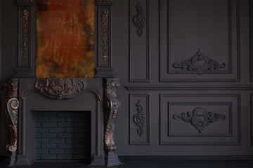 Decorative fireplace, vintage mirror and chandelier in classical black room interior
