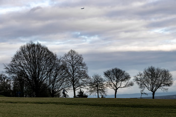 a bicycle rider in the park on a cold day