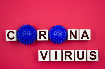 Corona virus, inscription on wooden cubes with a model of the virus on a red background. Like the MERS CoV or SARS virus, severe acute respiratory syndrome. Healthcare and medical concept.