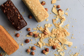 small Napoleonic cakes on a gray background with nuts delivery of sweets