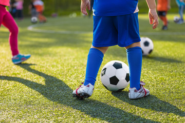 Children Training Soccer Ball Control. Football Ball Control Exercises For Kids. Young Soccer Players Practicing With Coach on the Sports Grass Field