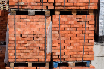 Bricks on pallets. Storage of bricks at construction site.