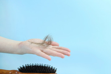 Fallen hair and a wooden comb. Copy space - concept of health problems, treatment, baldness,...