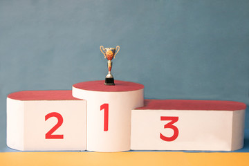 Podium for the winners of sports competitions with a gold cup in the first place. Steps of the...