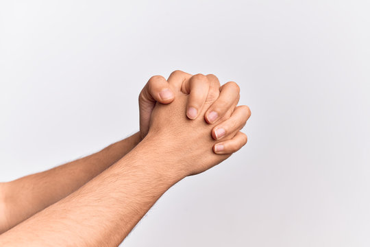 Hand of caucasian young man showing fingers over isolated white background praying with hands clasped, fold fingers religious gesture