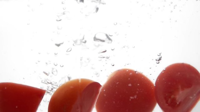 Photo of fresh sliced tomato dropped in water