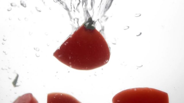 Photo of fresh sliced tomato dropped in water