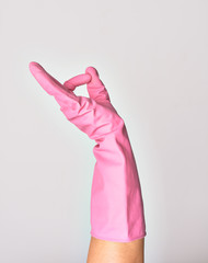 Hand of caucasian young woman wearing pink cleaning glove doing ok sign over isolated white background