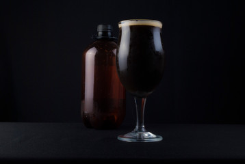 This bowl is made of crystal. The beer is a Dry Stout with grape must Tannat, Cabernet Franc, and Petit Verdot. Photo produced in low light, black background, lower exposure.