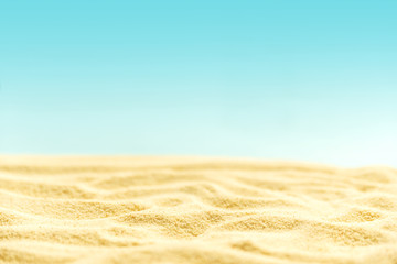 Tropical sandy beach with blurry blue ocean and sky. Summer background. Soft focus