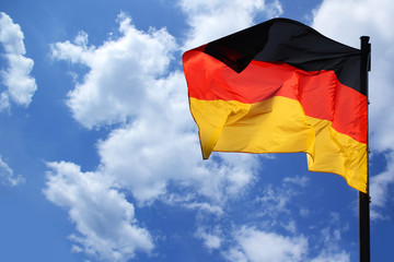 flag of the federal republic of Germany freely flutters in the wind against a blue sky, , concept of tourism, economy, politics, emigration, business