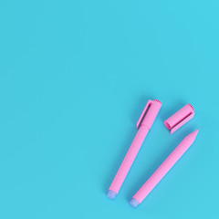 Pink marker pens on bright blue background in pastel colors. Minimalism concept